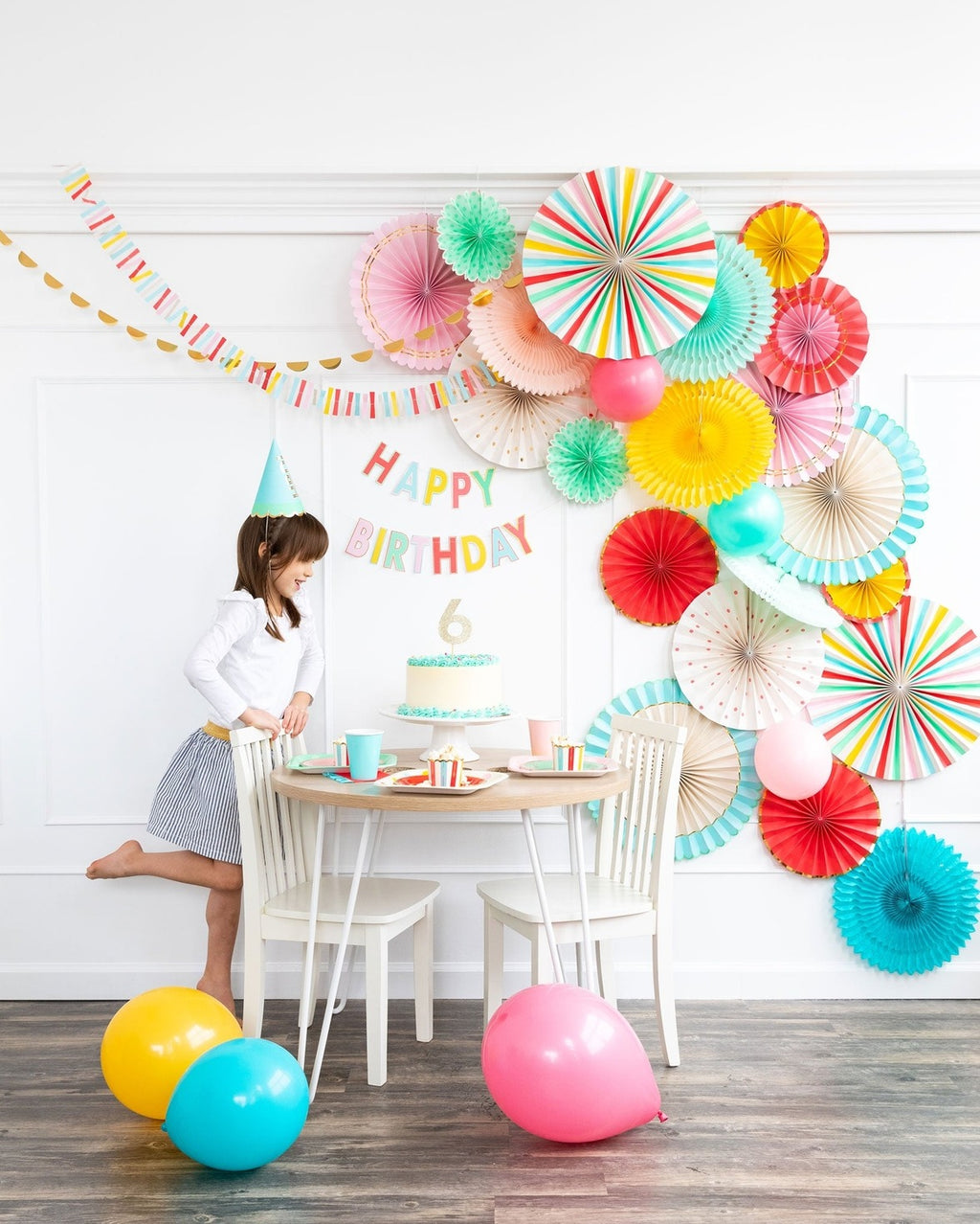Colorful birthday decorations with balloons banners and wall fans for kids party from Parte Haus party supply store in Bethesda MD