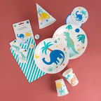 Colorful dinosaur birthday tableware with cups plates hats and napkins from Parte Haus party supply store in Bethesda MD