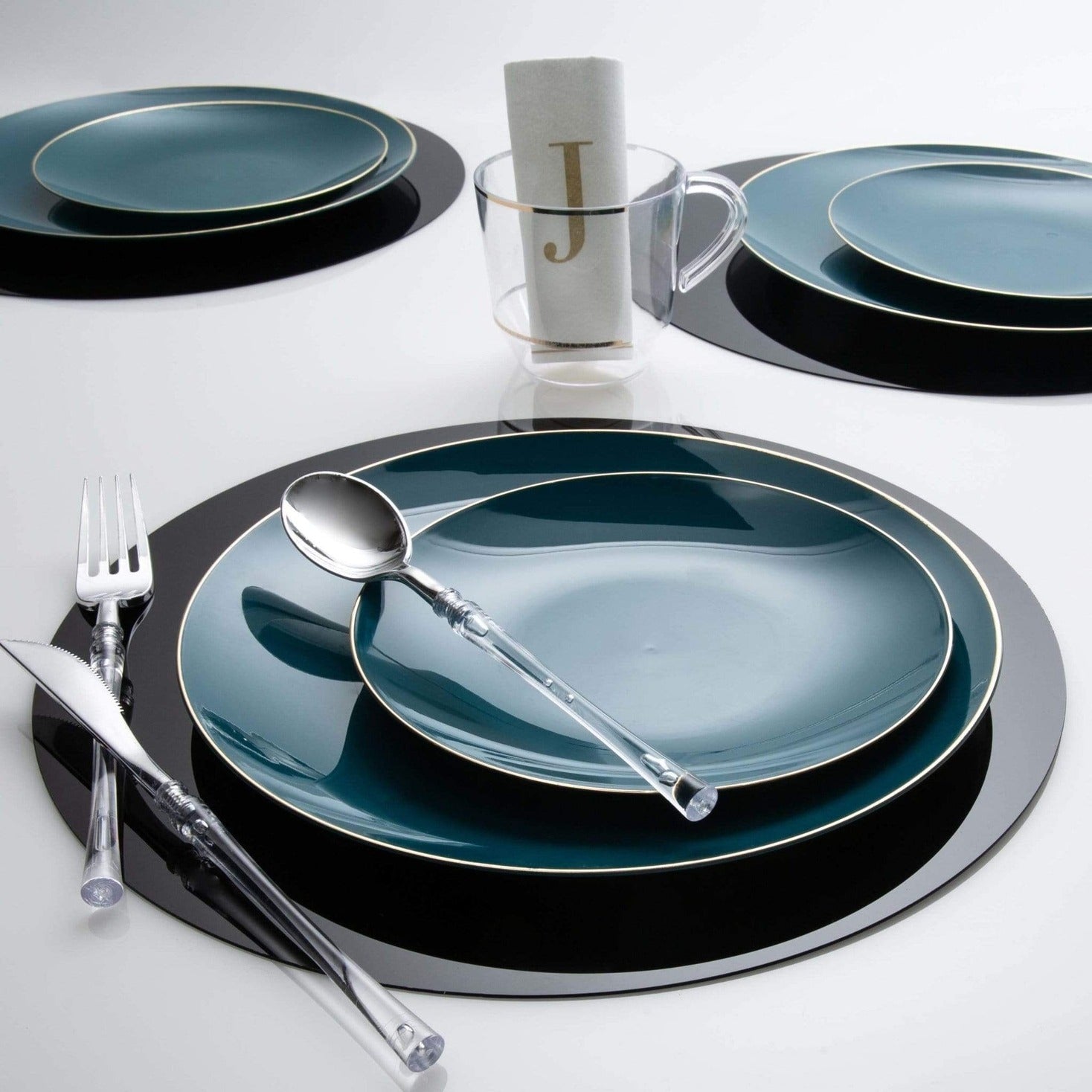 Blue and black dinnerware set with clear cutlery and monogram napkin table setting from Parte Haus party supply store in Bethesda Maryland