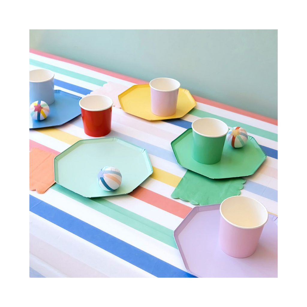 Pastel rainbow plates and cups with striped tablecloth kids birthday decor from Parte Haus party supply store in Bethesda MD