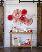 Red and white Christmas wall fans with Merry Christmas banner holiday decor from Parte Haus party supply store in Bethesda MD