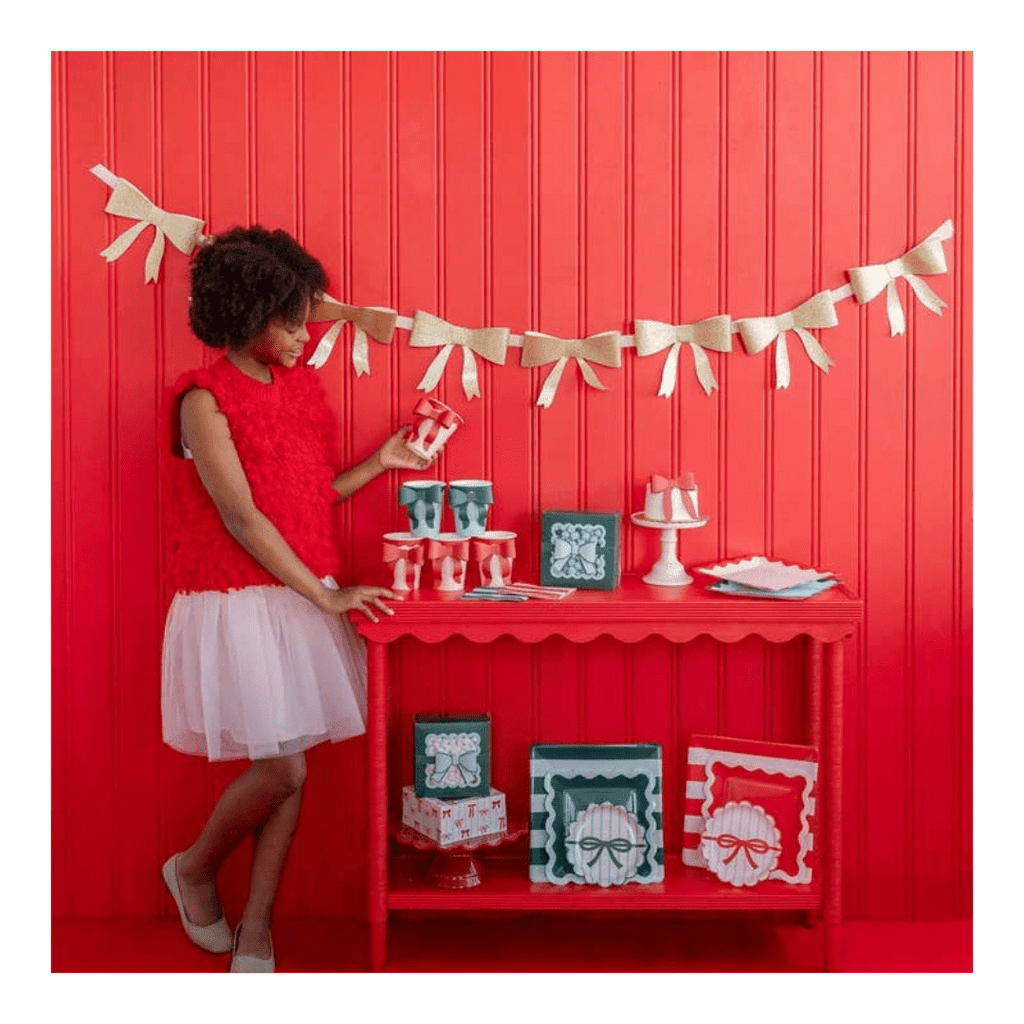 Red and white bow-themed party table setting Christmas banner decor from Parte Haus party supply store in Bethesda MD