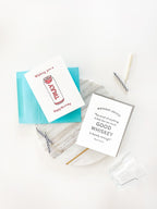 White letterpress birthday greeting cards with blue envelope on marble backdrop birthday theme from Parte Haus party supply store in Bethesda Maryland