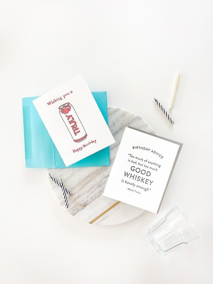 White letterpress birthday greeting cards with blue envelope on marble backdrop birthday theme from Parte Haus party supply store in Bethesda Maryland