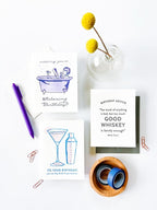 White and blue birthday greeting cards with drinks and birthday messages for birthday from Parte Haus party supply store in Bethesda Maryland