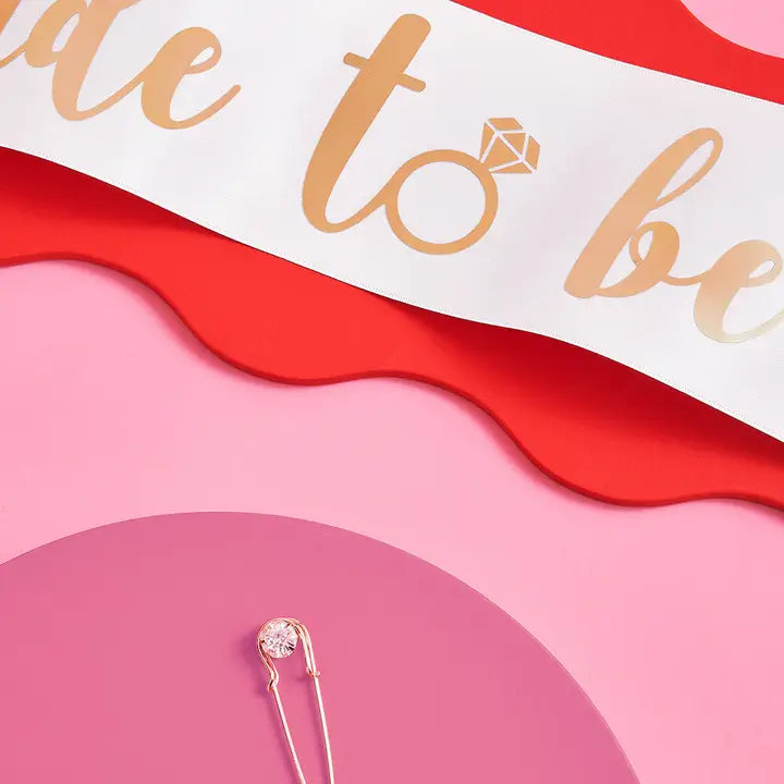 White bride to be sash with gold lettering for bachelorette party from Parte Haus party supply store in Bethesda MD