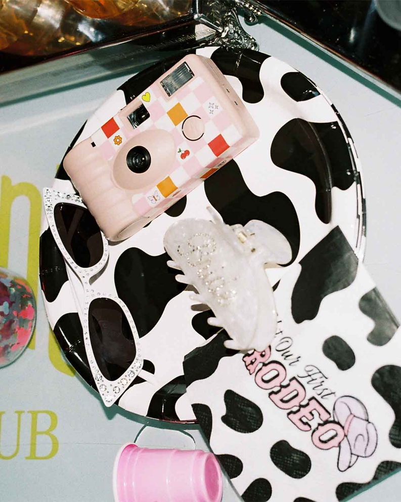 pink disposable camera cow print plate and western birthday decor from Parte Haus party supply store in Bethesda MD