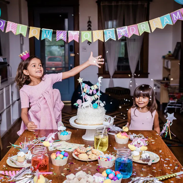 Colorful kids birthday banner and cake with unicorn toppers celebration from Parte Haus party supply store in Bethesda MD