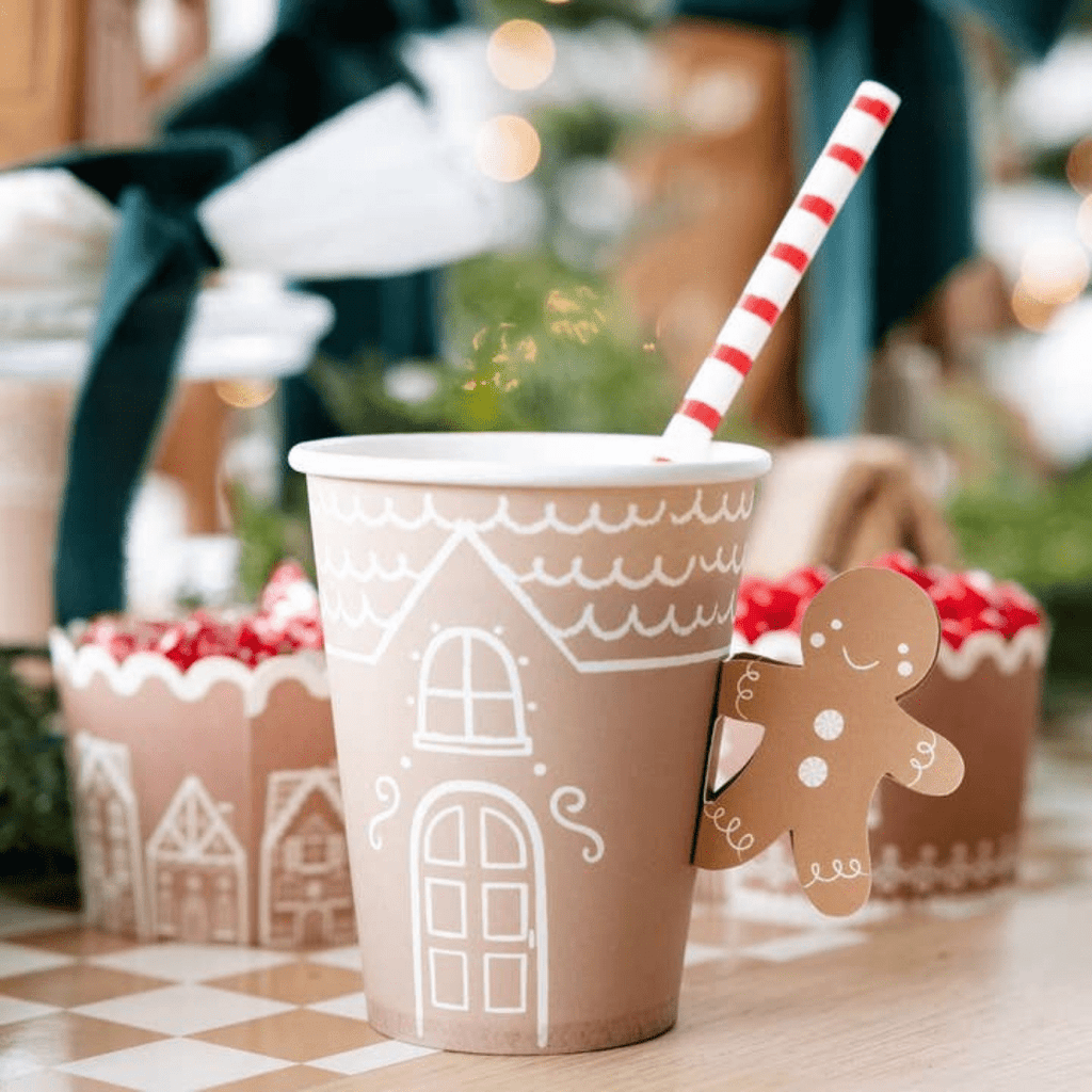 Brown gingerbread paper cup with white house design and candy cane straw Christmas theme from Parte Haus party supply store in Bethesda Maryland