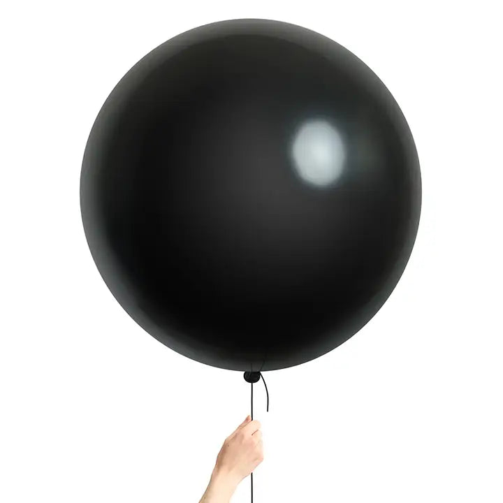 Black jumbo balloon held by hand for gender reveal celebration from Parte Haus party supply store in Bethesda MD