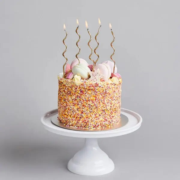 Gold curly candles on sprinkled birthday cake from Parte Haus party supply store in Bethesda MD