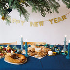 Gold Happy New Year banner with festive table New Year celebration from Parte Haus party supply store in Bethesda MD
