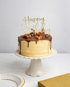 Gold Happy Birthday acrylic cake topper on chocolate cake birthday theme from Parte Haus party supply store in Bethesda MD