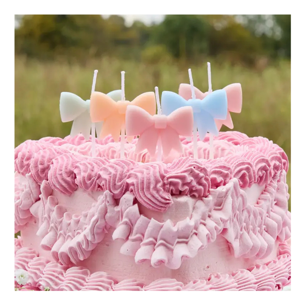 Pastel bow candles cake topper on pink frosted cake birthday theme from Parte Haus party supply store in Bethesda MD