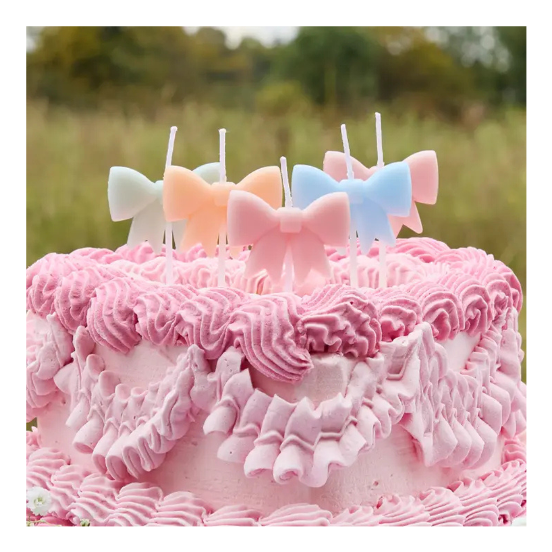 Pastel bow candles cake topper on pink frosted cake birthday theme from Parte Haus party supply store in Bethesda MD