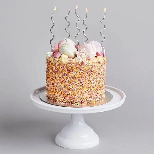 Silver wavy birthday candles on a pastel sprinkle cake for birthday from Parte Haus party supply store in Bethesda Maryland
