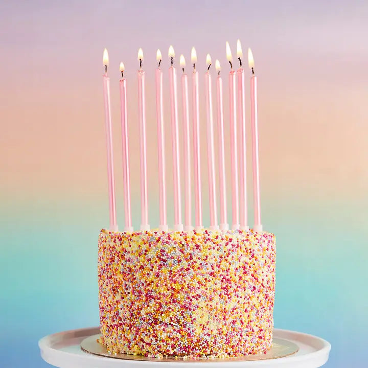 Pink birthday candles tall and slim on sprinkle cake for birthday celebration from Parte Haus party supply store in Bethesda MD