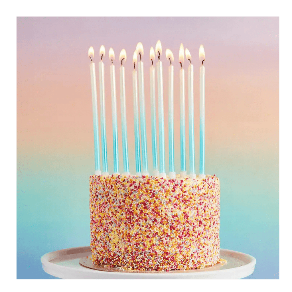 Blue tall birthday candles on rainbow sprinkle cake celebration from Parte Haus party supply store in Bethesda Maryland