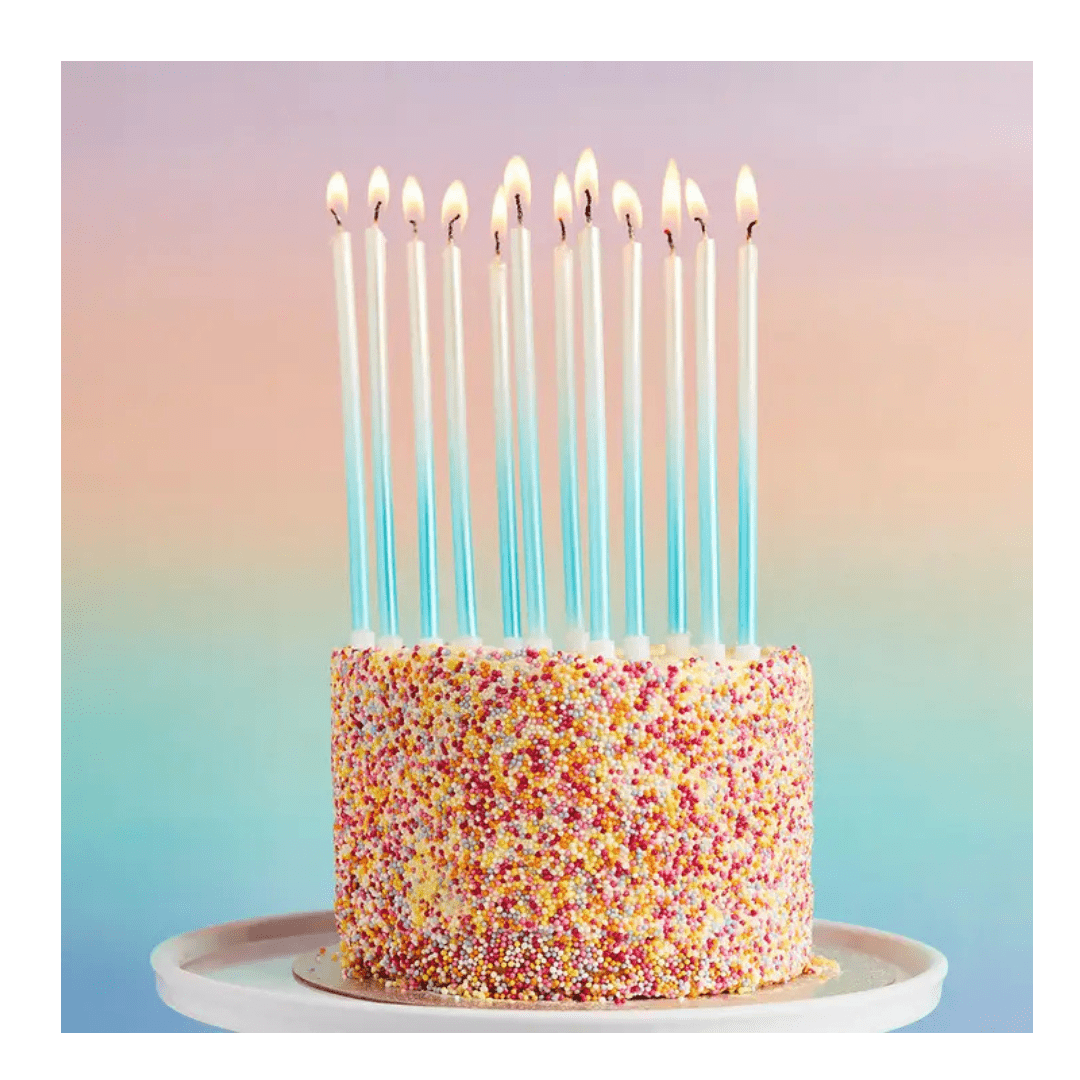 Blue tall birthday candles on rainbow sprinkle cake celebration from Parte Haus party supply store in Bethesda Maryland