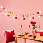 Red and gold heart garland with love themed table decor for Valentine’s Day from Parte Haus party supply store in Bethesda MD