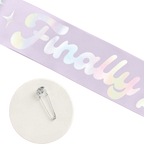 Iridescent pink graduation sash with finally text and safety pin from Parte Haus party supply store in Bethesda Maryland