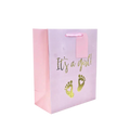 Pink gift bag with gold It's a girl text and baby feet for baby shower from Parte Haus party supply store in Bethesda MD.