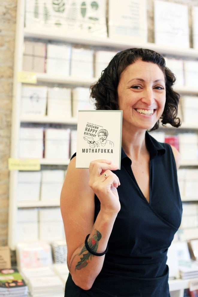 White letterpress birthday greeting card with bold text held by smiling woman birthday theme from Parte Haus party supply store in Bethesda Maryland