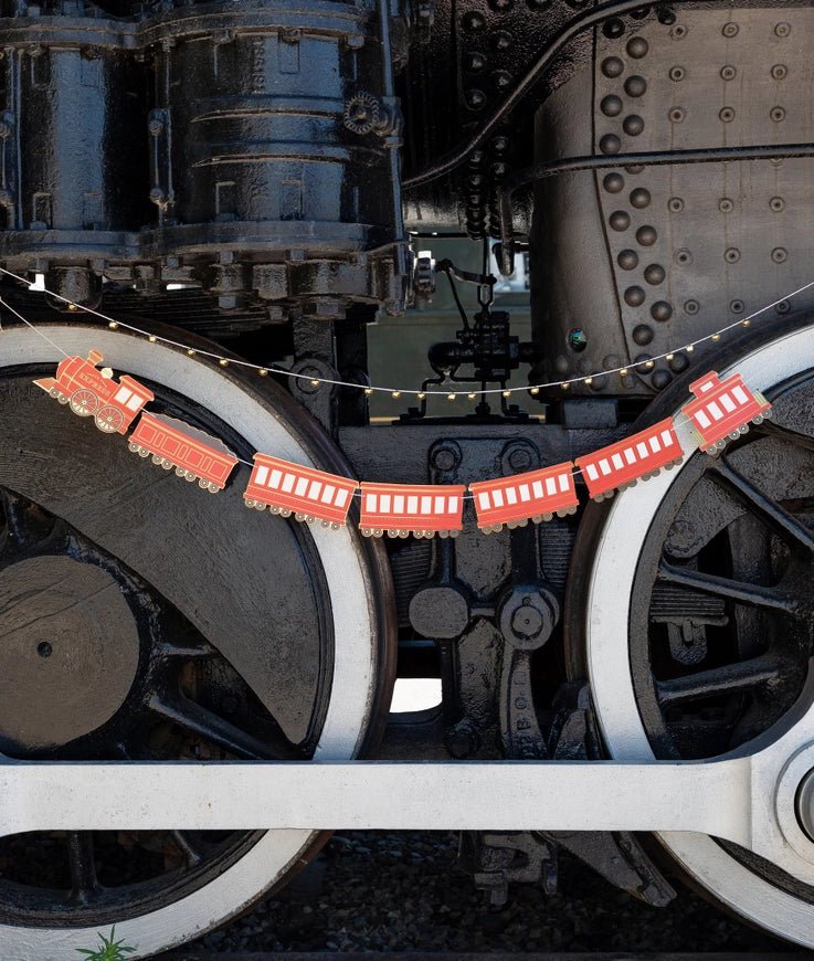 Red train banner garland hanging on locomotive for kids birthday from Parte Haus party supply store in Bethesda MD.
