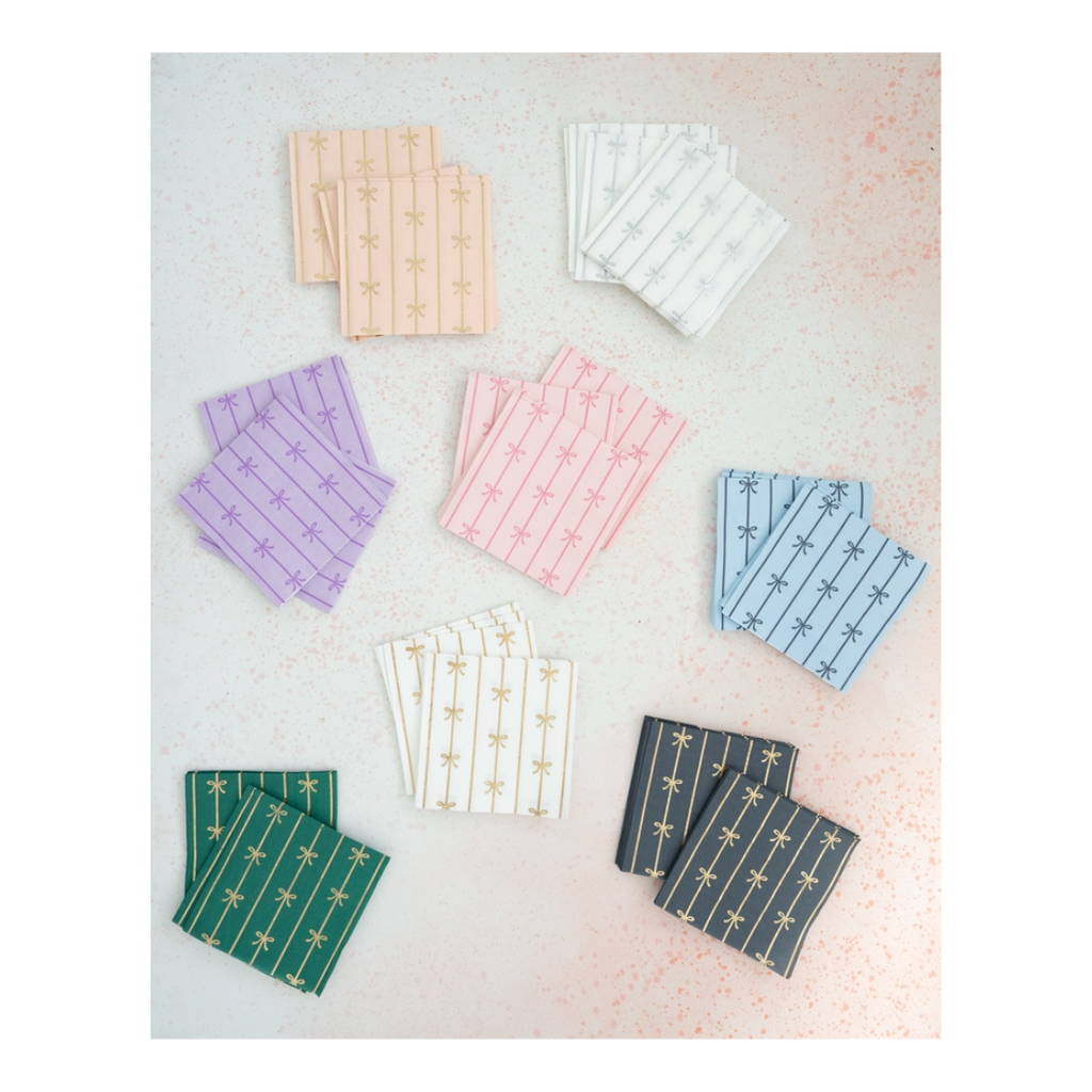 Multicolor cocktail napkins with gold bow designs for celebrations from Parte Haus party supply store in Bethesda MD.