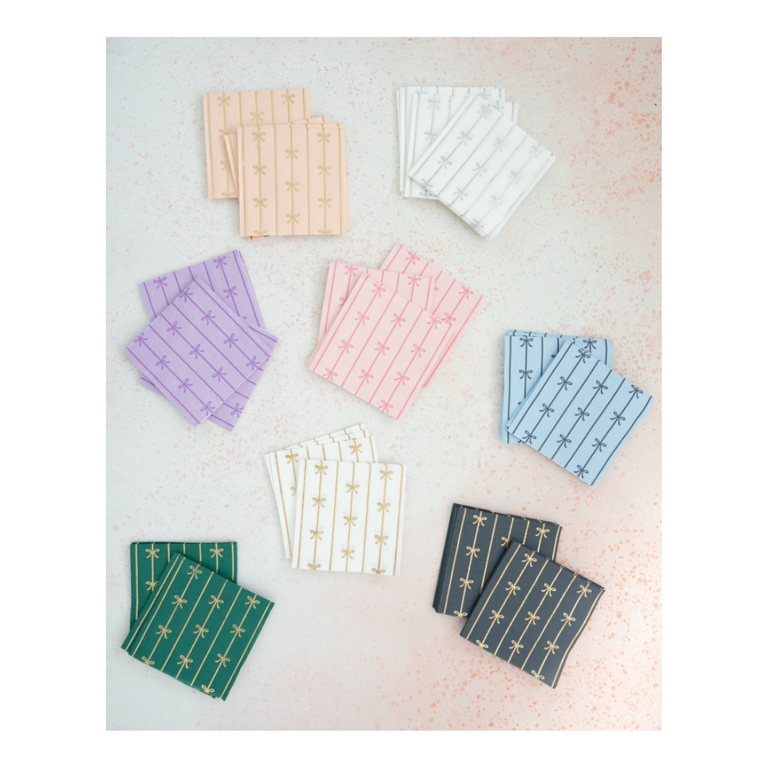 Multicolor cocktail napkins with gold bow designs for celebrations from Parte Haus party supply store in Bethesda MD.