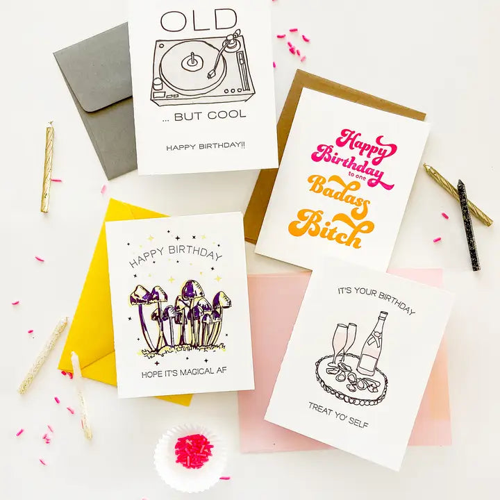 White and gold letterpress birthday cards with illustrations flat lay birthday theme from Parte Haus party supply store in Bethesda Maryland