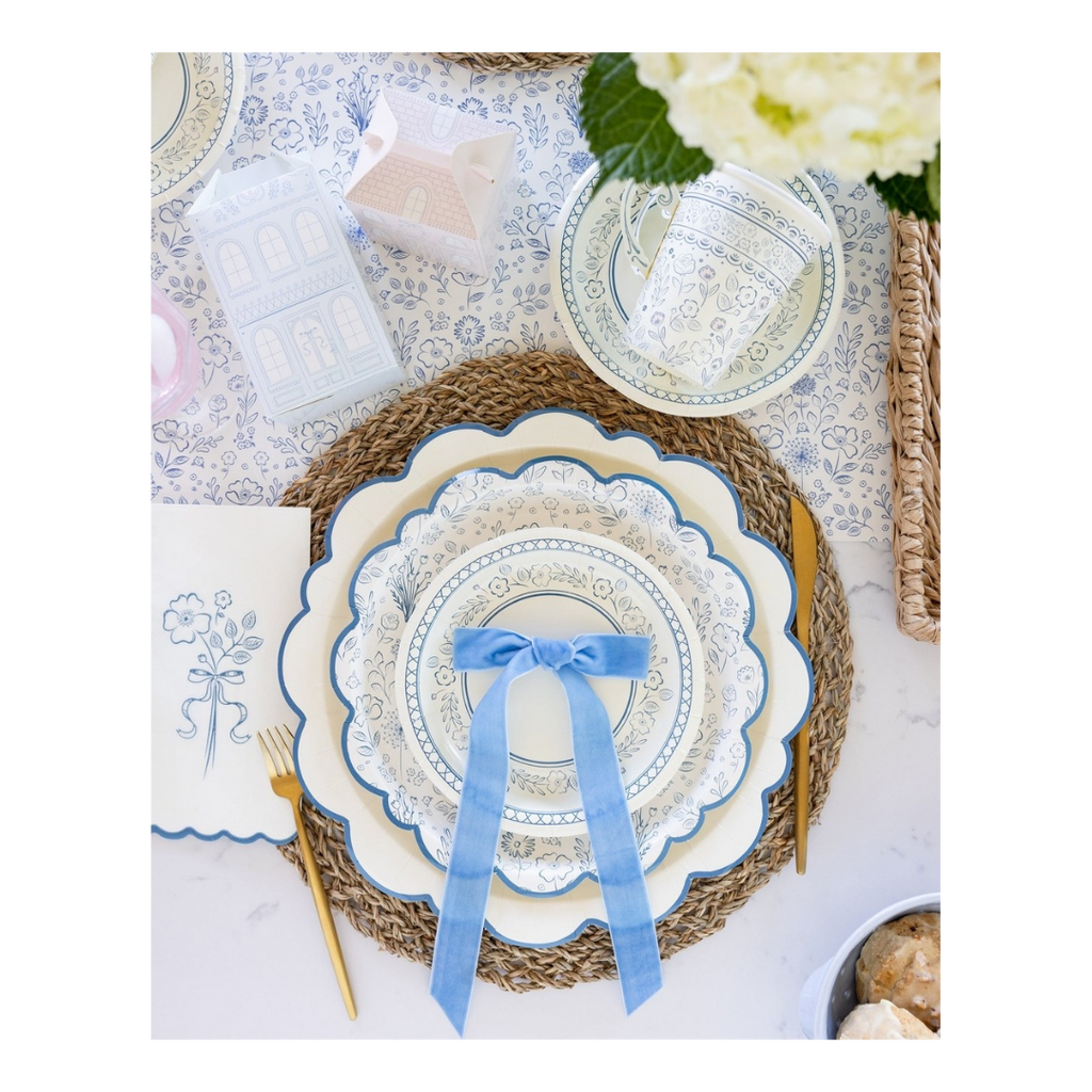 Blue and white floral paper plates with a blue ribbon bow on spring table setting from Parte Haus party supply store in Bethesda MD