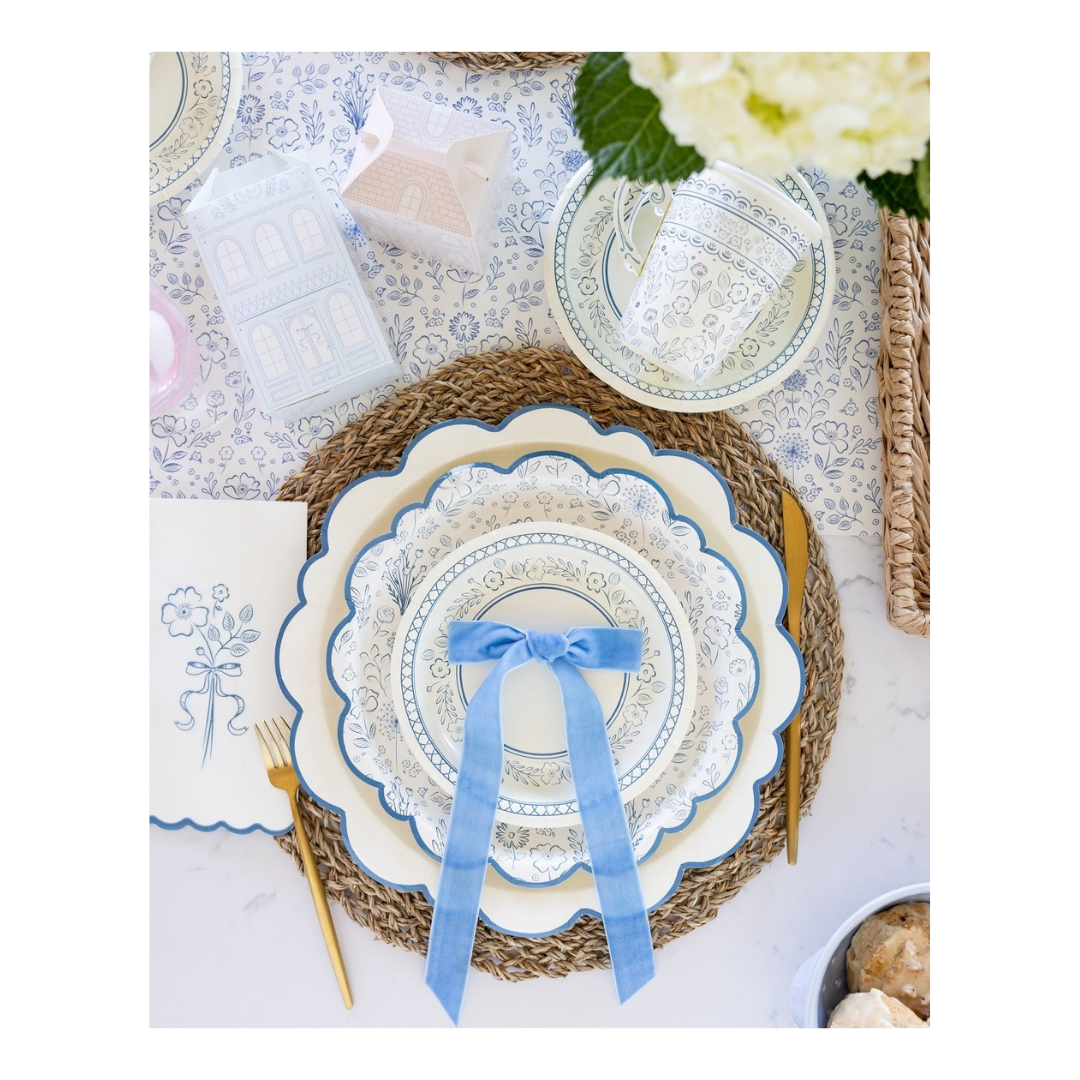 Blue and white floral paper plates with a blue ribbon bow on spring table setting from Parte Haus party supply store in Bethesda MD