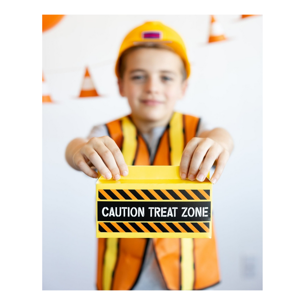 Orange construction costume kid with yellow Caution Treat Zone card birthday party from Parte Haus party supply store in Bethesda Maryland