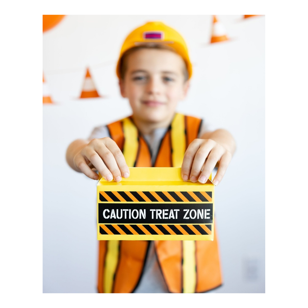 Orange construction costume kid with yellow Caution Treat Zone card birthday party from Parte Haus party supply store in Bethesda Maryland