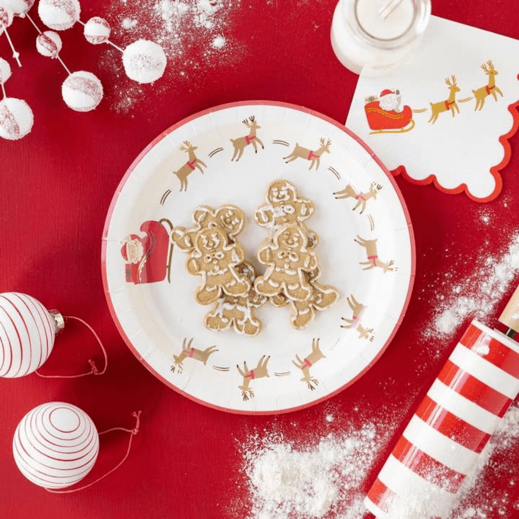 Red and white Christmas paper plate with reindeer and Santa sleigh holding gingerbread cookies for holiday from Parte Haus party supply store in Bethesda, Maryland