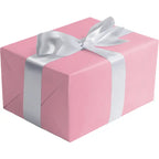 Pastel pink matte gift wrap featuring a white ribbon for birthdays from Parte Haus party supply store in Bethesda MD