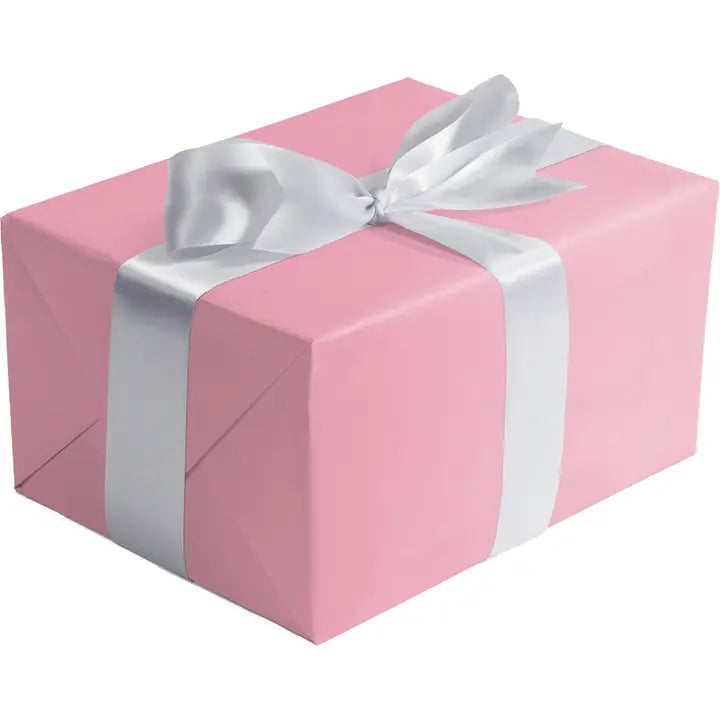 Pastel pink matte gift wrap featuring a white ribbon for birthdays from Parte Haus party supply store in Bethesda MD