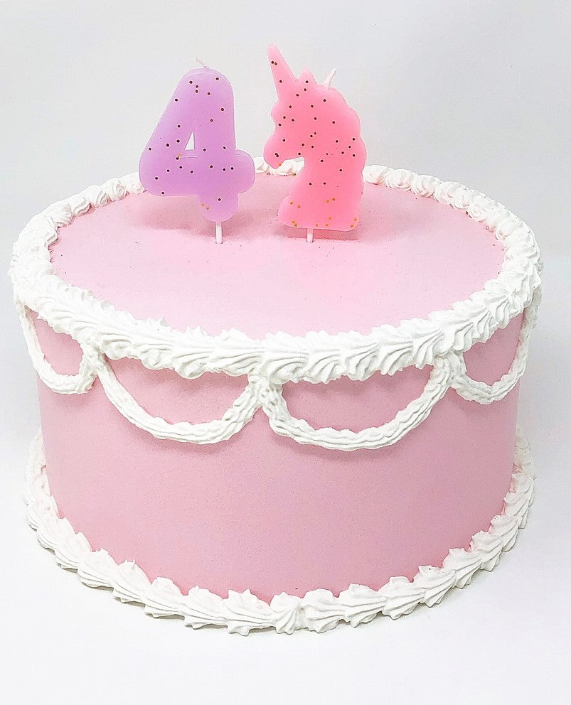 Pastel glitter number candles on a pink birthday cake unicorn party from Parte Haus party supply store in Bethesda Maryland