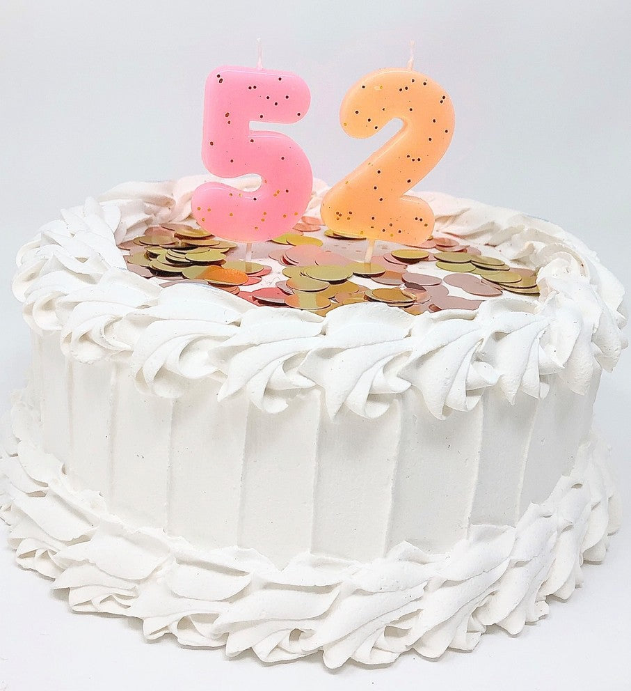 Pastel glitter number candles pink and orange on birthday cake celebration from Parte Haus party supply store in Bethesda Maryland