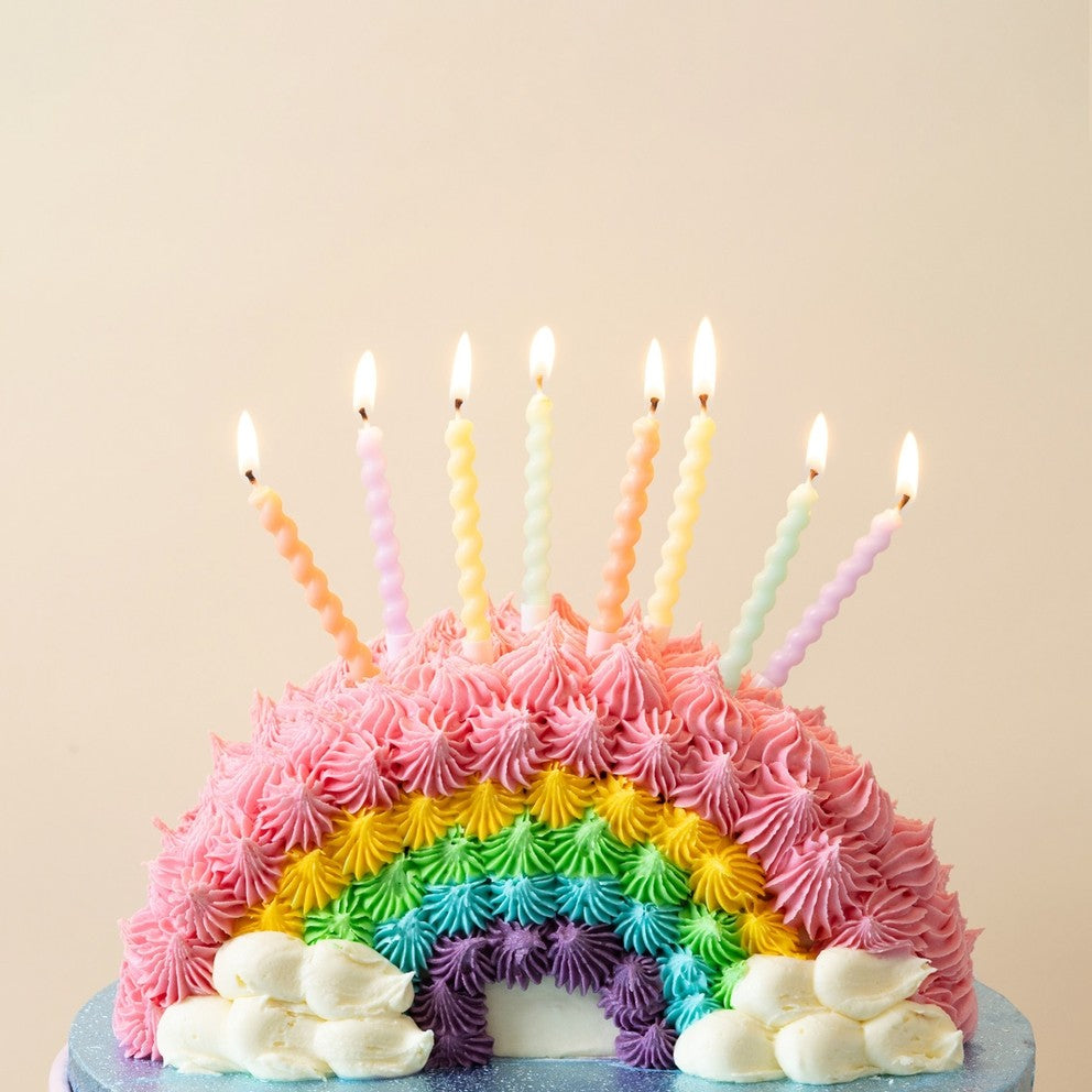 Pastel twisted birthday candles on a rainbow cake for birthday celebration from Parte Haus party supply store in Bethesda Maryland