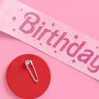 Pink birthday girl sash with glittery stars and safety pin for birthday from Parte Haus party supply store in Bethesda Maryland