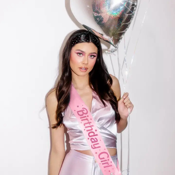 Pink Birthday Girl sash with stars worn by woman holding heart balloon birthday theme from Parte Haus party supply store in Bethesda MD