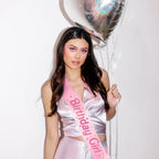 Pink Birthday Girl sash with stars worn by woman holding heart balloon birthday theme from Parte Haus party supply store in Bethesda MD