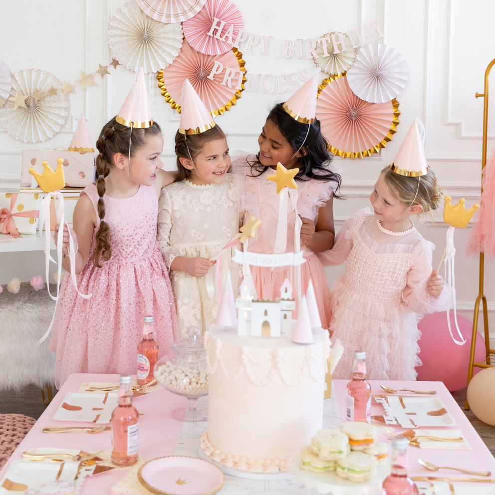 Pink princess party hats with gold trim and girls at birthday celebration from Parte Haus party supply store in Bethesda MD