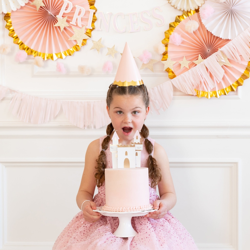 Pink princess party hats with gold trim worn by girl at princess birthday theme from Parte Haus party supply store in Bethesda Maryland