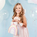 Rainbow pastel party bags with handles held by a smiling child birthday theme from Parte Haus party supply store in Bethesda MD