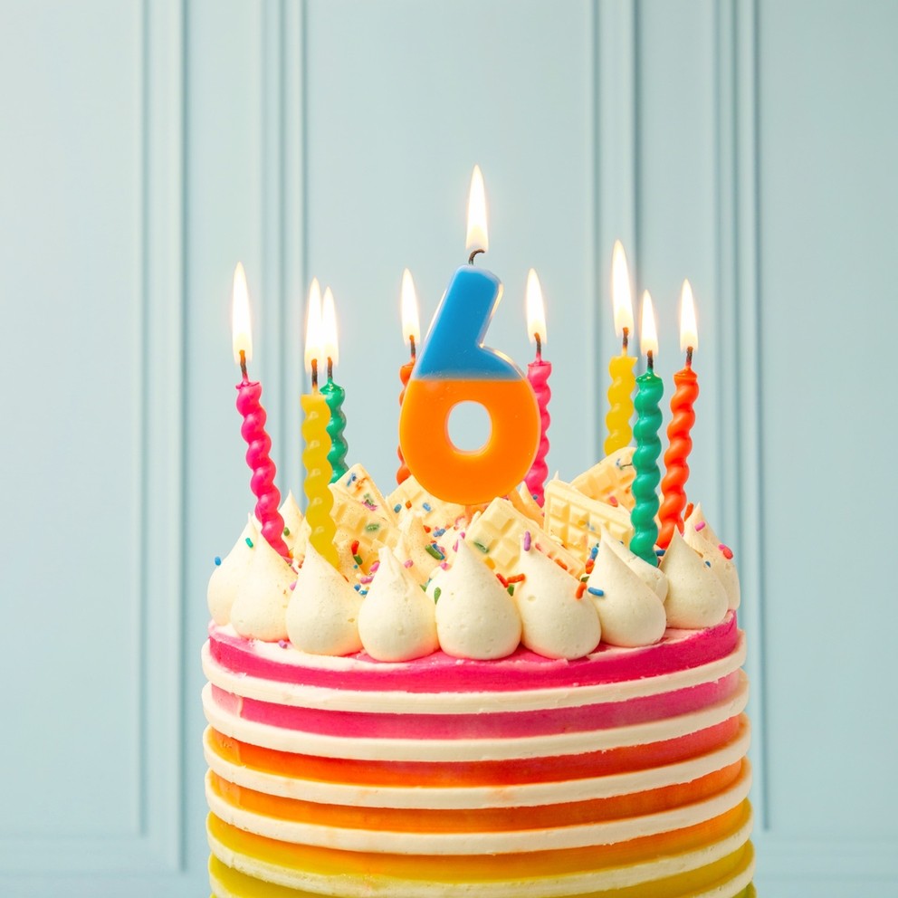 Rainbow twisted birthday candles on a striped cake birthday celebration from Parte Haus party supply store in Bethesda MD
