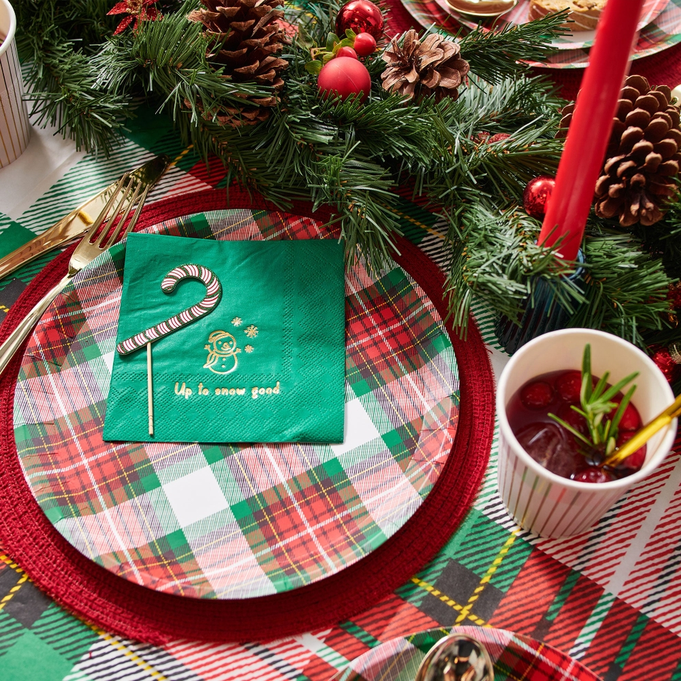 Red and green plaid plates with gold cutlery and pine decor Christmas from Parte Haus party supply store in Bethesda MD