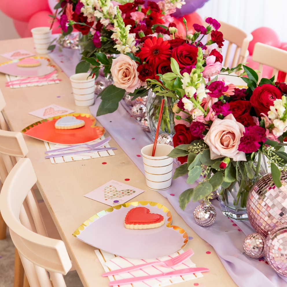 Red and lilac gold rimmed large dinner plates with heart cookies on romantic party table Parte Haus party supply store in Bethesda MD